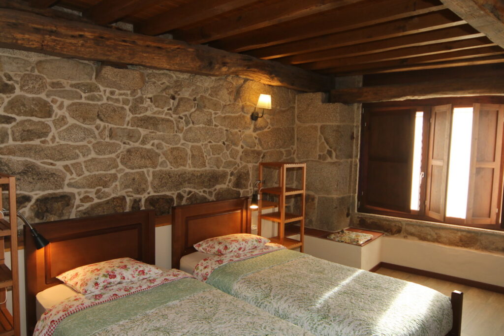 2 camas en la Suite Parladoiro con una ventana detras