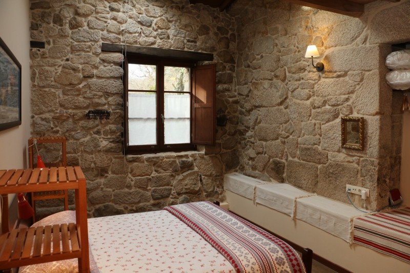 Cama sillon y ventana en la habitacion capilla