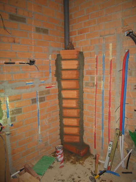 Antes de poner mortero en las paredes hay todavía unas cuantas cosas que hacer: tapar tuberías, poner tubos y distribuidores de calefacción, aquí en el alpendre.
