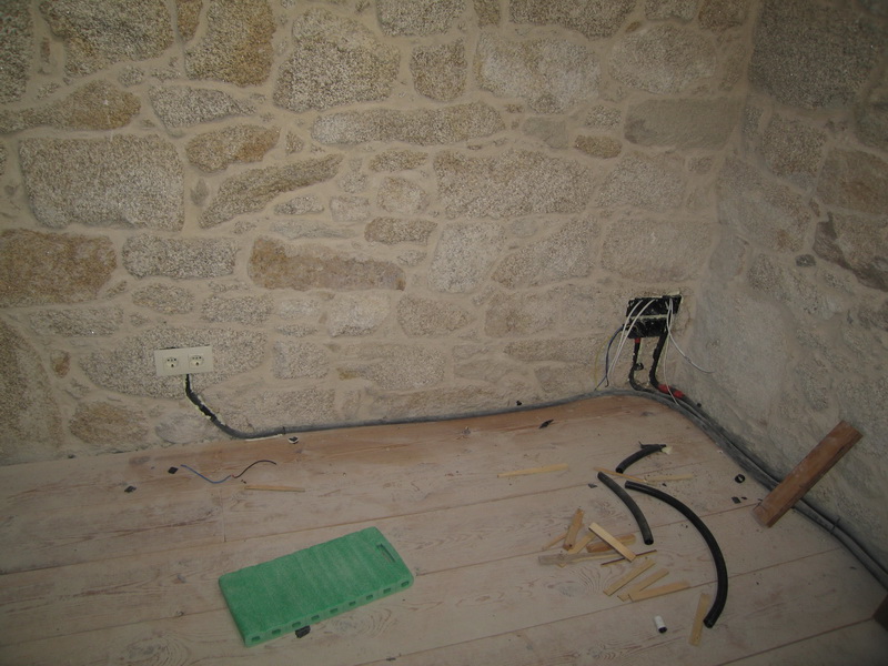 Instalación eléctrica: al principio habíamos dejado parte de la instalación en las paredes de piedra a la vista, pero finalmente Thomas decidió dar un poco uso al percutor y se puso a empotrar interruptores, enchufes y alguna que otra línea. Parecían pocos pero resultaron ser 32 unidades.