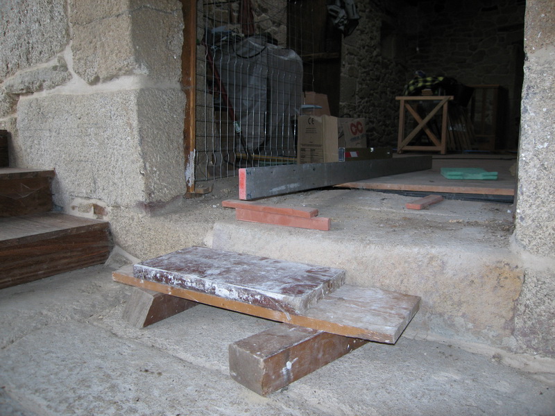 El peldaño de entrada era todo menos recto y ni siquiera estaba a nivel con el suelo de madera, así que antes de colocar la puerta había que solucionar ese problema.